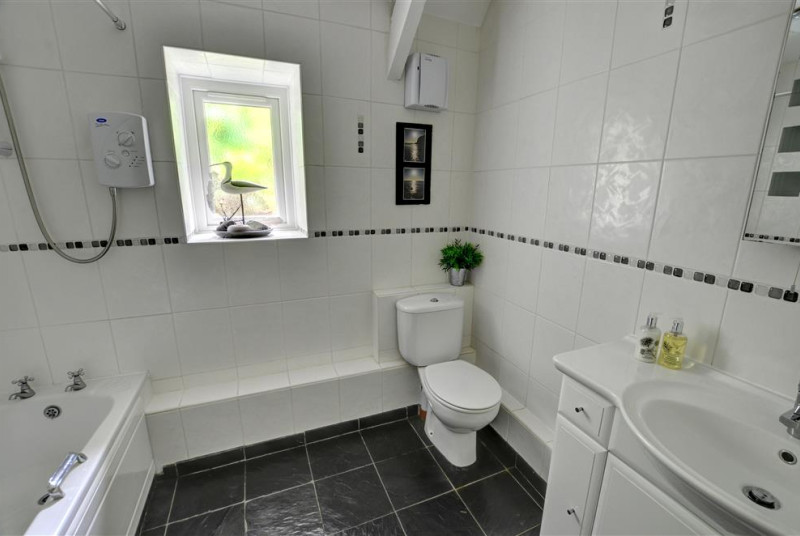 The main bathroom with bath over shower, WC and large sink
