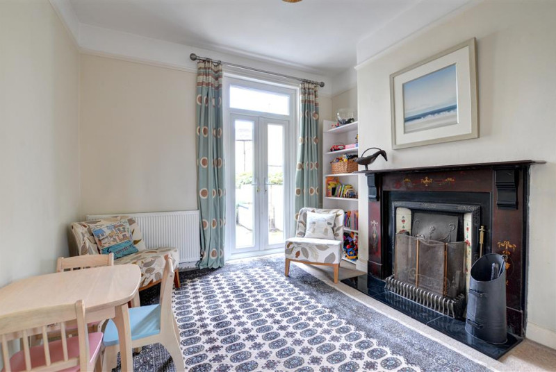 This Sitting Room can double as a children's playroom. It has French doors which lead out to the rear Garden area.