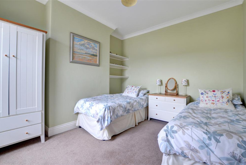 This twin Bedroom has a chest of drawers and wardrobe for storage.