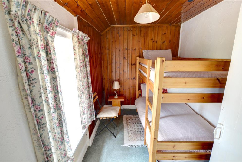 Twin Bedroom with bunk beds and a chest of drawers behind the door.