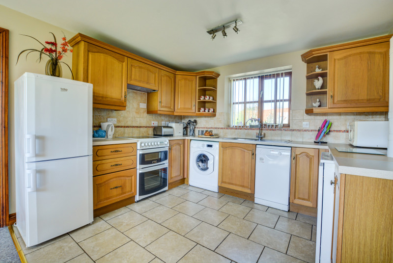 The kitchen features an electric cooker, fridge/freezer, microwave, washer/dryer, dishwasher.
