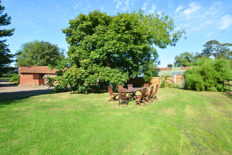 Shared open-plan lawned area with garden furniture and barbecue, ideal for al fresco dining