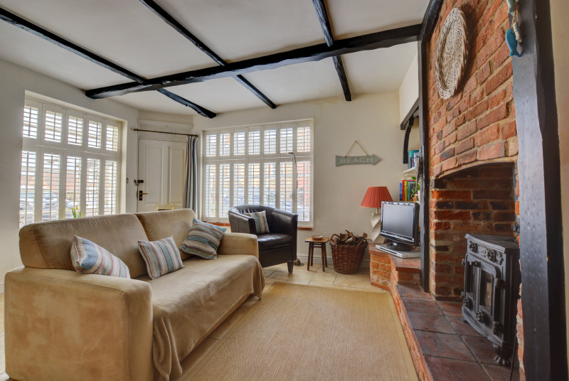 Open plan sitting room with woodburner and ample seating. 