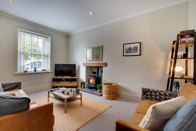 A spacious lounge with woodburning stove, ideal to cosy up in front of after a busy day exploring the Yorkshire Dales