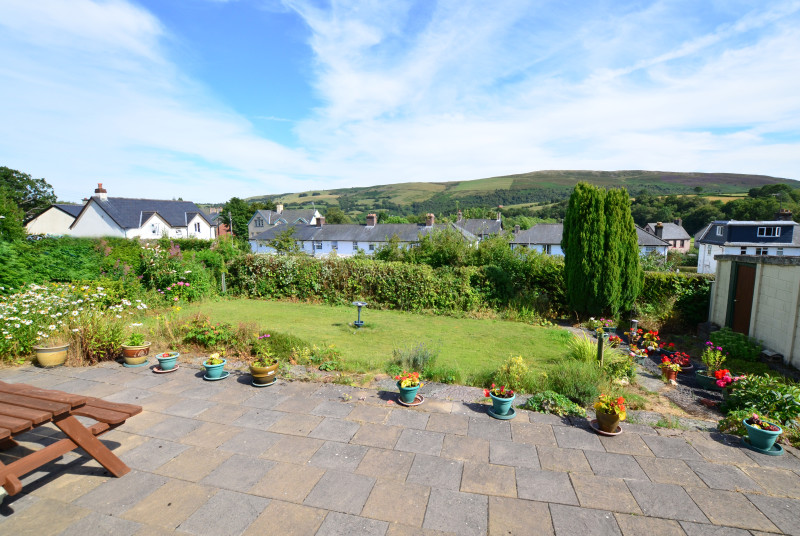 There is a good sized patio and lawned garden to the rear of the bungalow, with views over houses to the surrounding hills