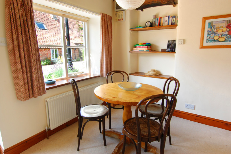 Dining table and chairs beside the window.