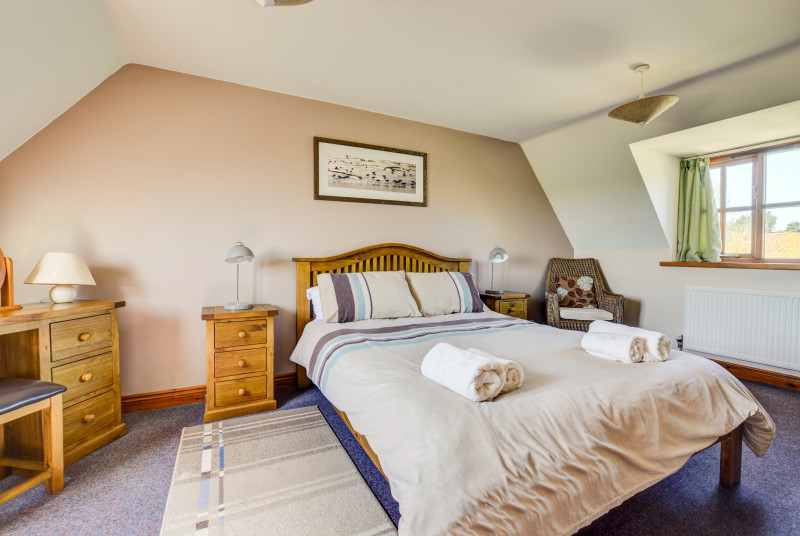 A comfortable and spacious double bedded room with television.