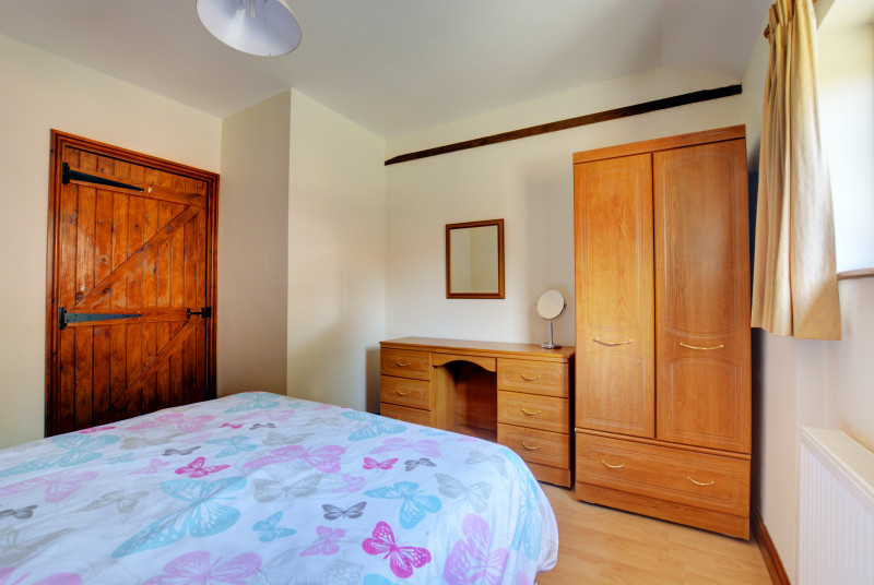 Traditional furniture offers plenty of storage in this double bedroom