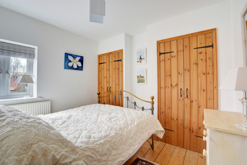 Double bedroom with built-in storage and pine floors