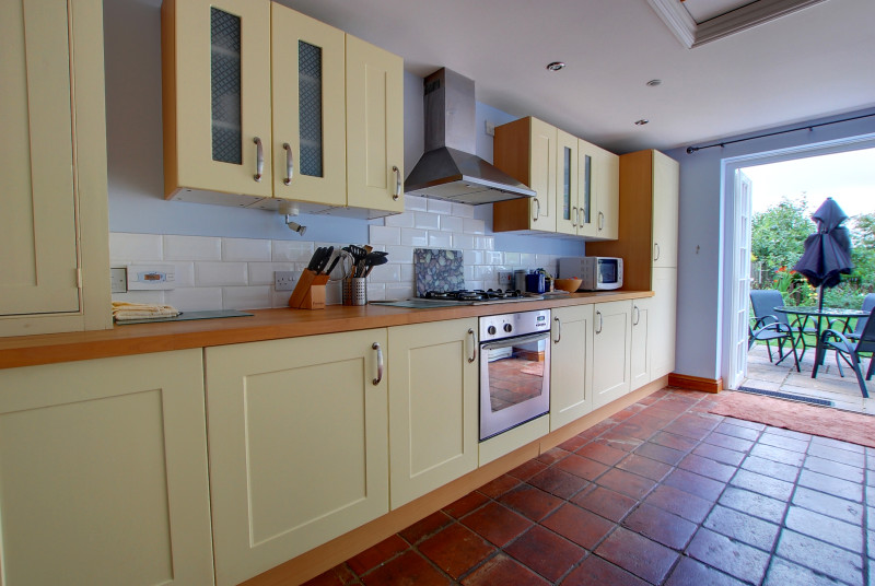 The spacious kitchen opens off the dining area and has cream cupboards and a ceramic tiled floor