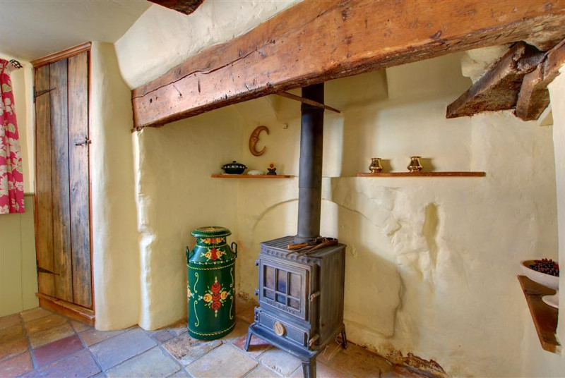 The little wood burner set in the large open fireplace of the dining room.