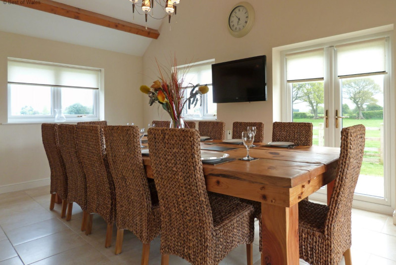 Large dining table with wall mounted TV and stunning views
