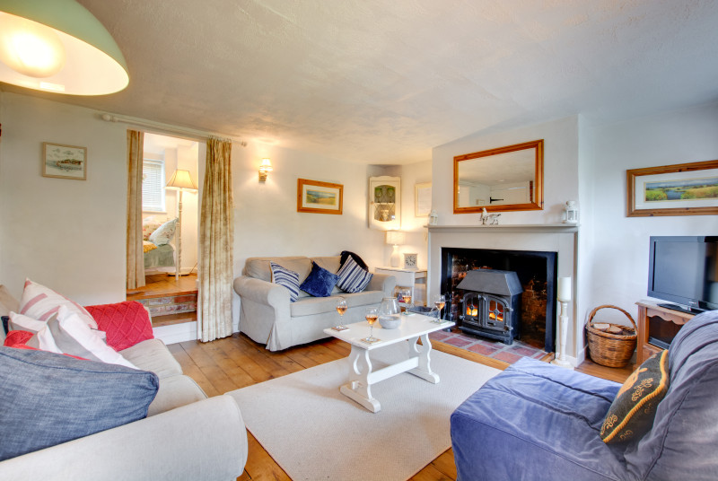 Sitting room with cosy wood burner, comfortable seating and TV