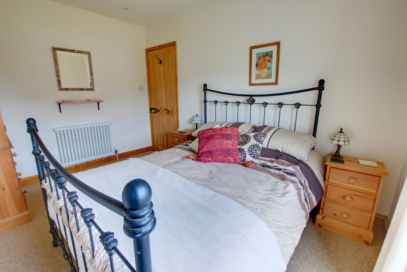 The double room has a double bed with an attractive iron bedstead, the room is light and airy and the window looks out over the front garden