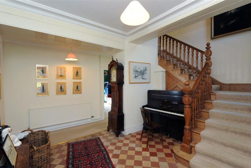 Enter into the welcoming hall with impressive pine staircase.