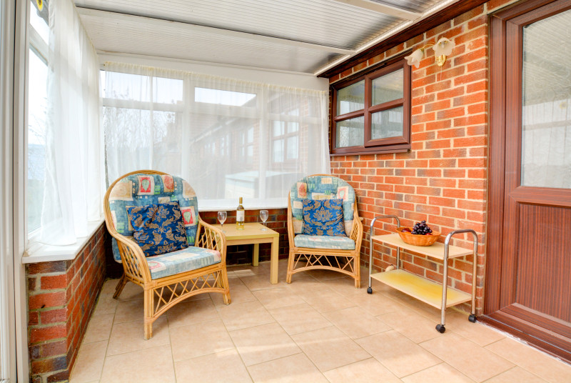 A lovely conservatory with comfortable seating.