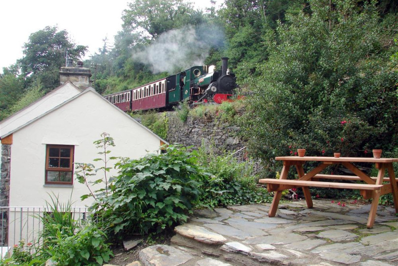 There is a steeply terraced garden and patio area to the side of the cottage, with picnic bench, and views of the steam trains running immediately behind the cottage on the Ffestiniog Railway