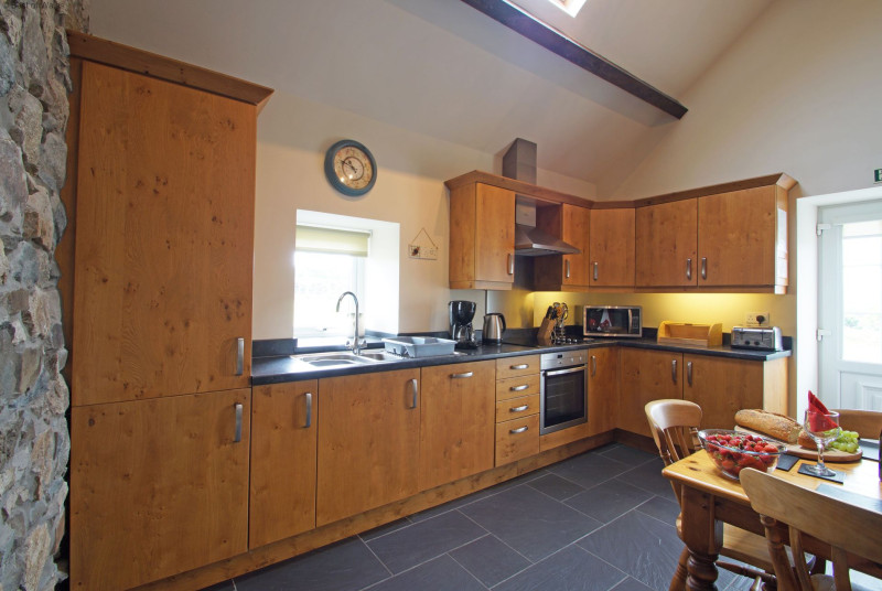 A character oak kitchen with slate floor and a farmhouse pine table