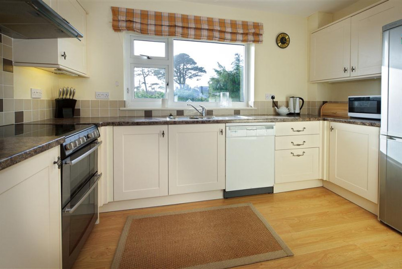 Kitchen has been fitted with white units to reflect natural sunlight