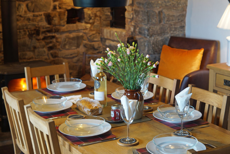 Dining table in front of a beautiful inglenook and woodburner