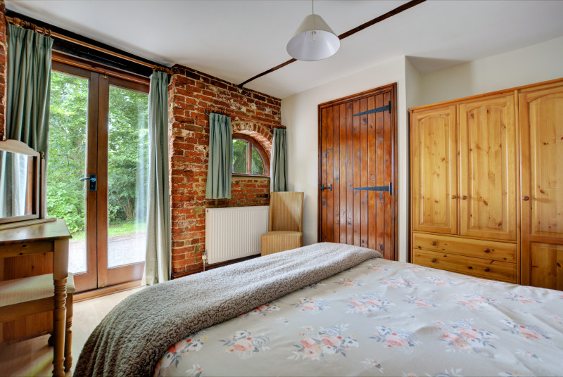Charming double bedroom with a double bed, French doors and en-suite shower room with shower cubicle