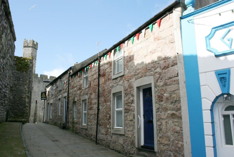 This mid-terraced stone cottage in Caernarfon is situated just inside the castle walls (to left of photo), in a pedestrianised street of cafes, bars and restaurants