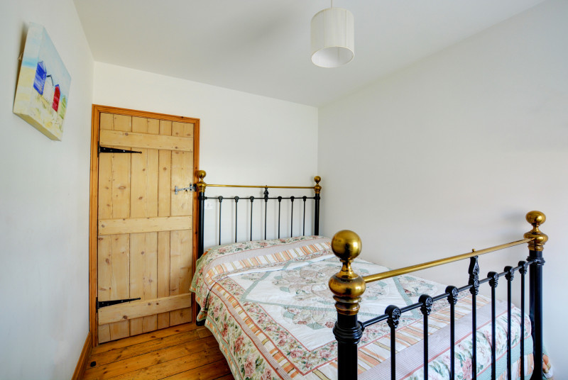 Compact and bright double bedroom with wrought iron double bed