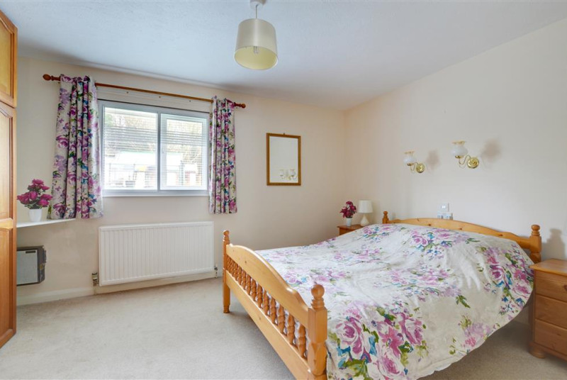 The spacious master bedroom looks over the garden