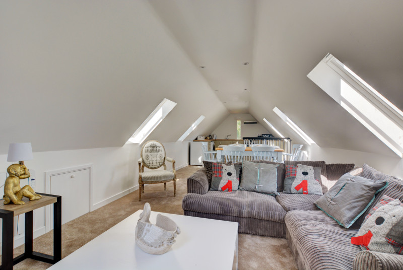 Open plan living area with comfortable seating, coffee table and velux roof windows