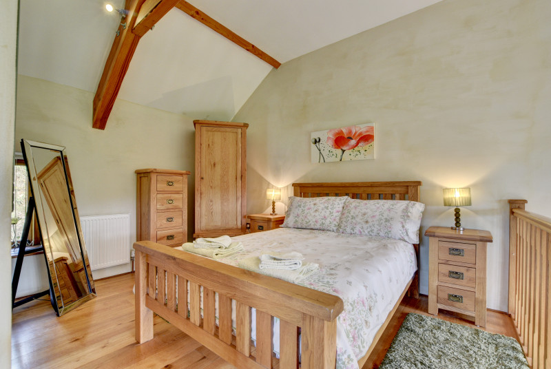On a mezzanine floor above, the stylish bedroom has a pristine en suite shower room