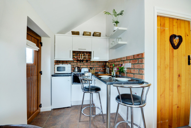 The kitchen area includes a handy breakfast bar and stools.