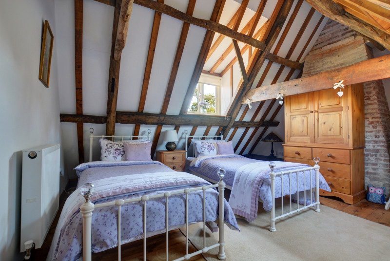 Super double bedroom with twin beds, exposed brickwork and character beams