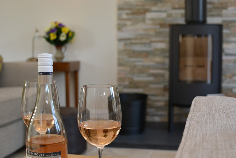 View of sitting room with log burner and a shared bottle of wine