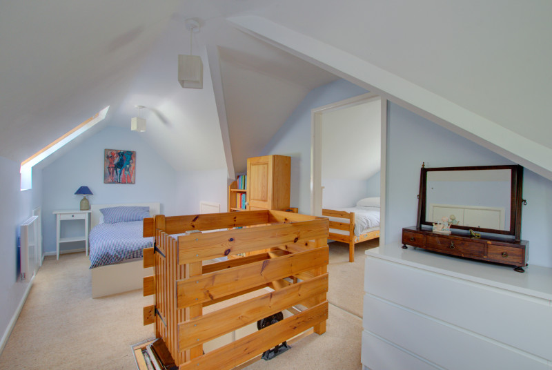 The first twin room has beds to each end of the room, sloping ceilings, velux windows, and the ladder area in the centre of the room