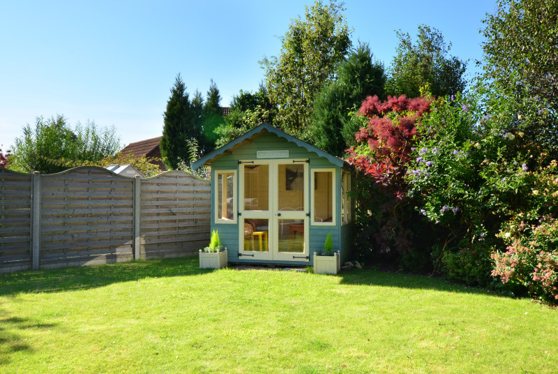 Mainly lawned garden with patio, summer house, barbecue and table and chairs for al fresco dining