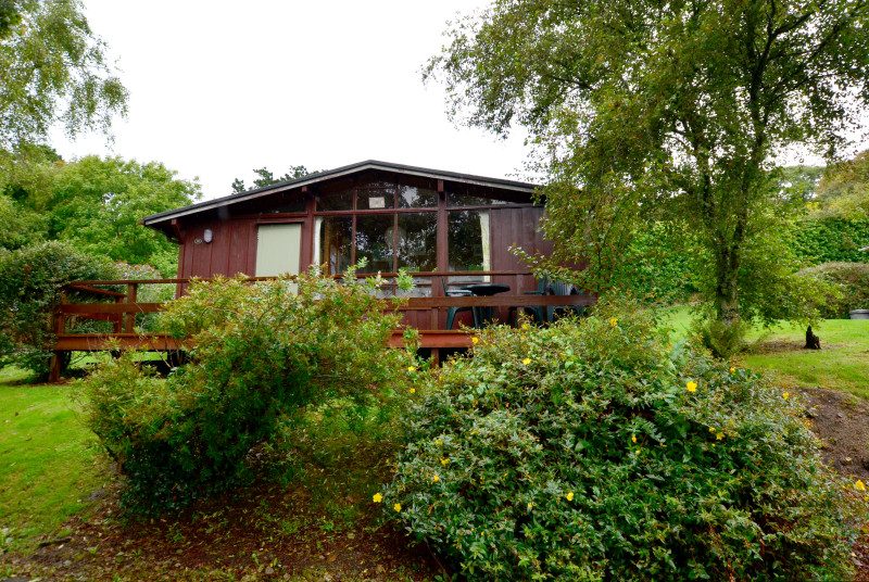 The lodge has a balcony to the front, with garden furniture