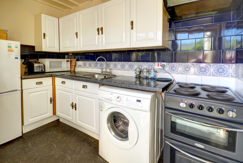 The compact kitchen sits to the rear with a door to a small, private, peaceful patio-style outdoor space