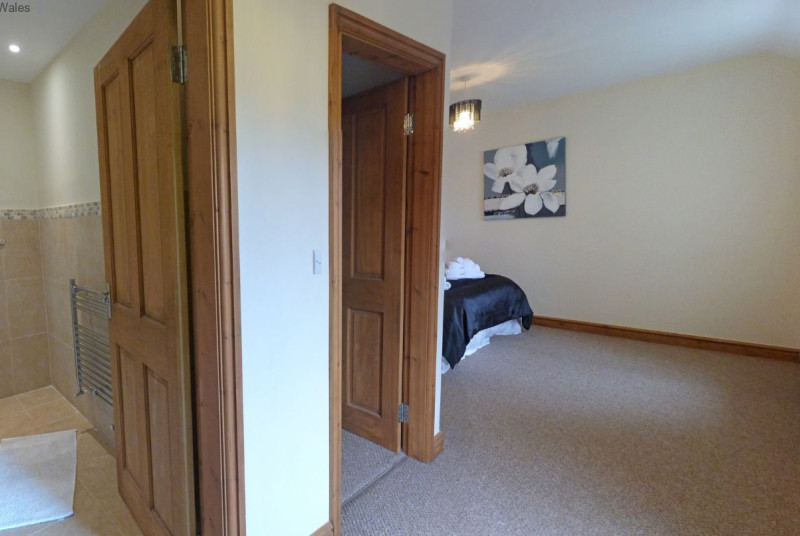 En suite facilities comprising enclosed shower cubicle, WC and wash basin.