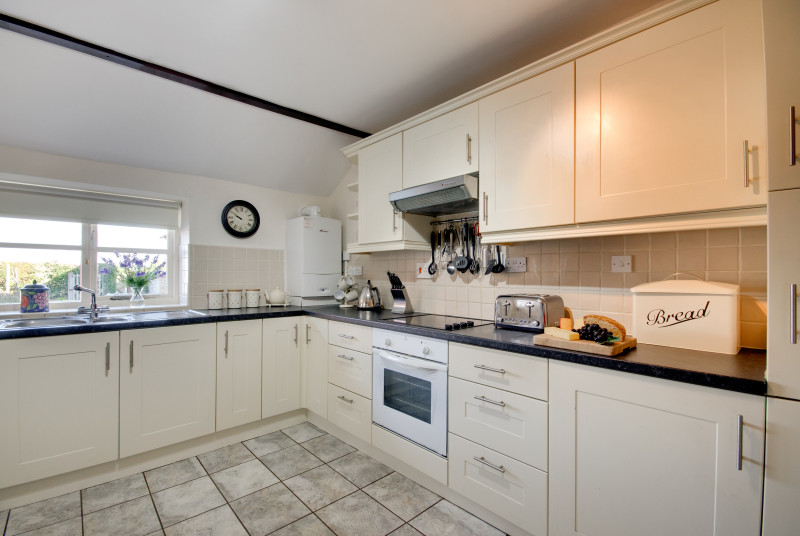 The spacious kitchen is fitted with modern units and has an electric cooker, microwave, fridge/freezer, tumble dryer and dishwasher.