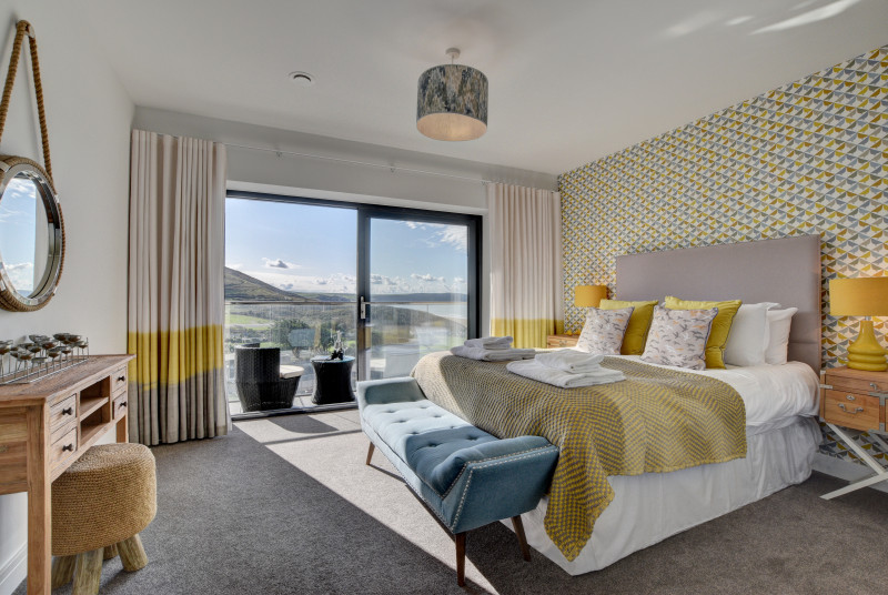 The spacious master king size bedroom has been stylishly decorated in yellows and greys