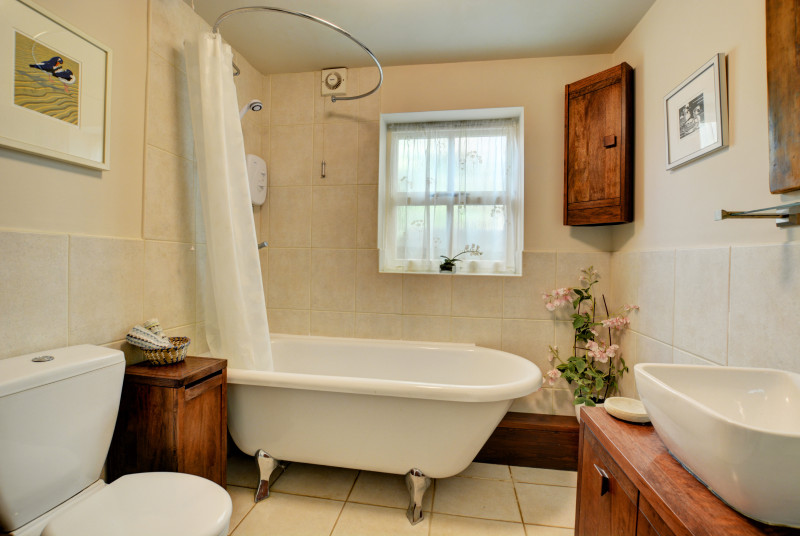 Bathroom with over the bath shower, washbasin and wc