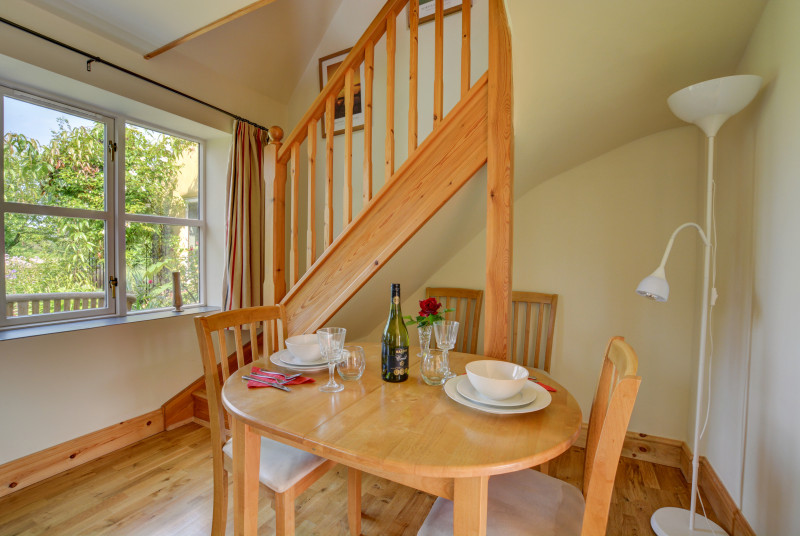 A modern wooden dining table with high back dining chairs.