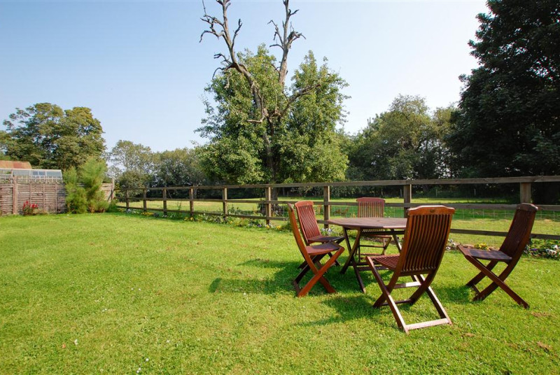Shared open-plan lawned area with garden furniture and barbecue, perfect for al fresco dining