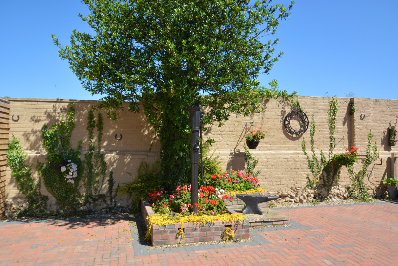 View of the courtyard, with the ornamental pump with flower bed surrounding.