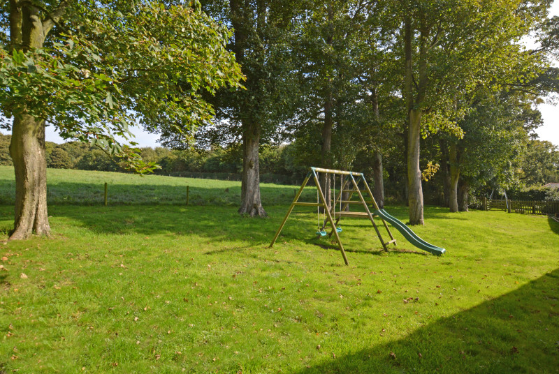Garden area with childrens play swing and slide