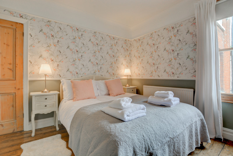 First floor bedroom with king-size bed and feature fireplace