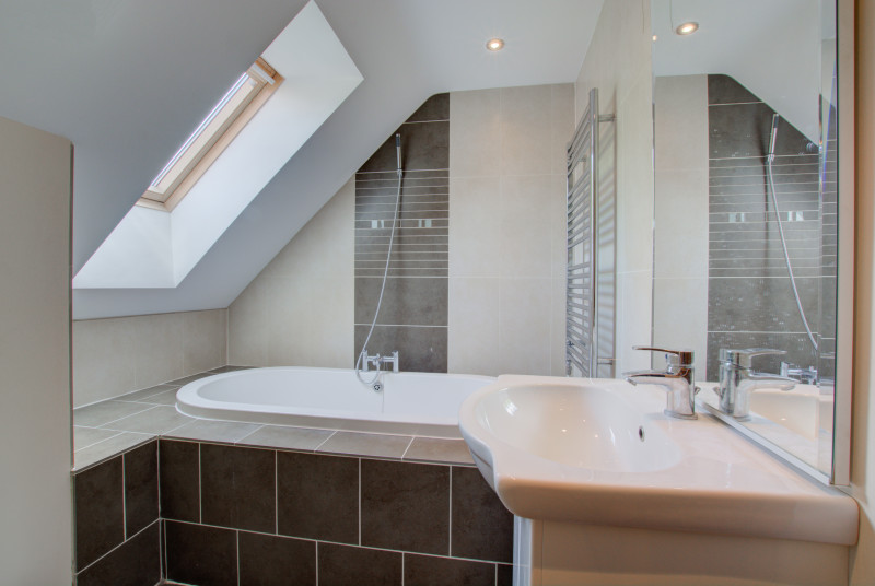 Beautiful modern bathroom with sloping ceiling & heated towel radiator.