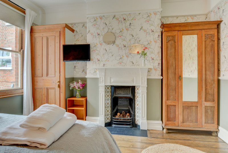 First floor bedroom with feature fireplace and king-size bed