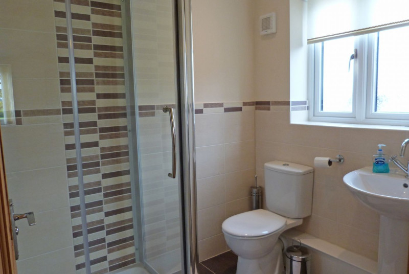 En suite facilities include an enclosed shower cubicle, WC and wash basin.