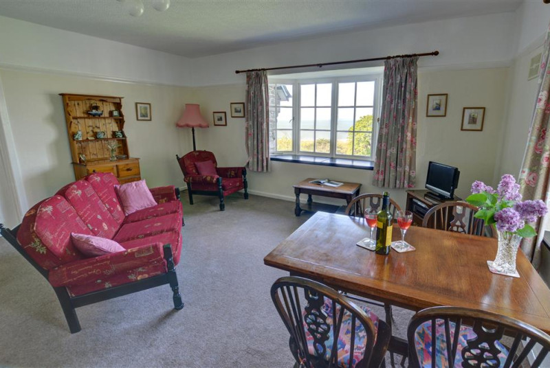 The living room has a cottage suite and oak dining table and chairs